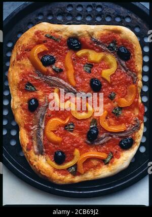 Eine hausgemachte Pizza auf Tomatenbasis mit Oliven, Paprika, Basilikum und Sardellen Belag Stockfoto