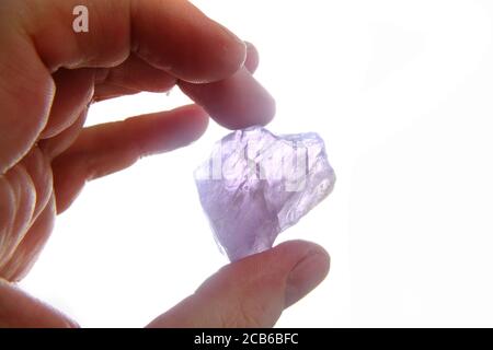 Violetter Amethyst in der menschlichen Hand isoliert auf dem Weiß Hintergrund Stockfoto