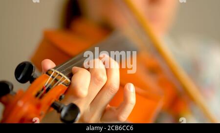 Junge Frau spielt Geige. Hände des Musikers, Nahaufnahme. Vorderansicht. Stockfoto