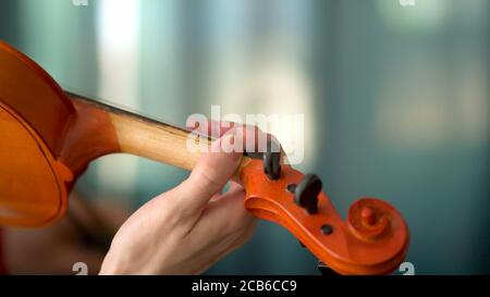Junge Frau spielt Geige. Hände des Musikers, Nahaufnahme. Vorderansicht. Stockfoto