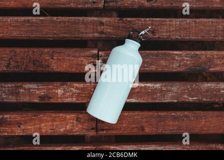 Draufsicht auf eine Metallflasche auf einem Holztisch Stockfoto