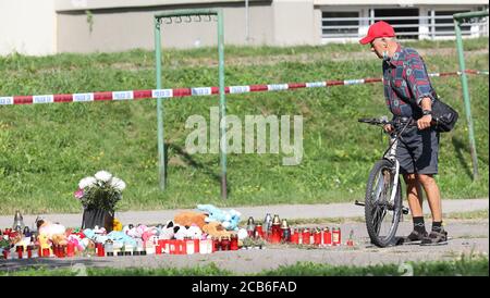 Bohumin, Tschechische Republik. August 2020. Ein Radfahrer beobachtet brennende Kerzen für die Opfer des Brandanschlags in Bohumin, Tschechische Republik, am 11. August 2020. Elf Menschen starben bei einem Brand in einem Fertighaus in Bohumin, Tschechien, am 8. August. Alle 11 Opfer des Bohumin-Hauses wohnten in einer Wohnung im 11. Stock, wo ein Feuer ausbrach. Sechs starben im Inneren, fünf nach dem Sprung aus dem Fenster. Alles deutet darauf hin, dass tödliche Bohumin Feuer Brandanschlag war. Zu den Opfern gehören drei Kinder. Kredit: Petr Sznapka/CTK Foto/Alamy Live Nachrichten Stockfoto