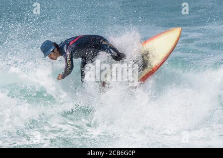 Wilde spektakuläre Action als Surfer reitet eine Welle am Fistral in Newquay in Cornwall. Stockfoto