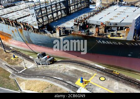 Das Containerschiff Hansa Europe, das durch die Schleuse Miraflores auf dem Panamakanal, Panama, fährt Stockfoto