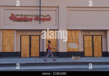 Los Angeles, Usa. August 2020. Am Montag, den 10. August 2020, geht eine Frau mit ihrem Hund an einer Hochzeitskapelle am Broadway in der Innenstadt von Los Angeles vorbei. Kleine Unternehmen sind wieder in der Schwebe, da der Ausbruch des Coronavirus tobt und das Hilfsprogramm der Regierung mit 659 Milliarden Dollar zu Ende geht. Foto von Jim Ruymen/UPI Kredit: UPI/Alamy Live Nachrichten Stockfoto