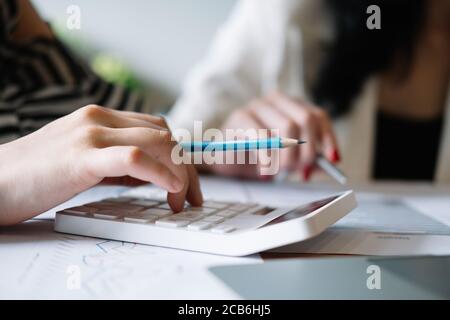 Nahaufnahme von Geschäftsleuten mithilfe eines Rechners zur Berechnung des Geschäftsdatenberichts Im Büro