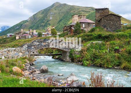 Traditionelle mittelalterliche Svanetian Turm beherbergt, steinerne Brücke über Patara Enguri Fluss, Ushguli Dorf, Region Swanetien, Kaukasus, Georgien Stockfoto