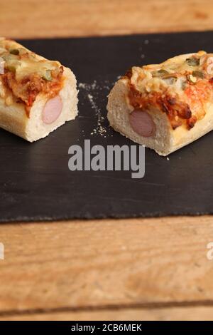 Vertikale High-Angle-Aufnahme von einem Hot Dog Sandwich mit Der Käse wird auf einer hölzernen Oberfläche halbiert Stockfoto