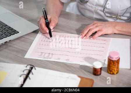 Kardiologin, die in der medizinischen Praxis ein EKG-Diagramm untersucht Stockfoto