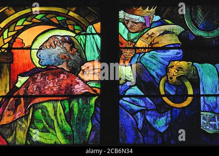 Szene aus dem Leben der Bruderheiligen Cyril und Methodius. Buntglas, das 1930 vom Jugendstil- und Art déco-Künstler Alphonse oder Alfons Maria Mucha (1860-1939) im Veitsdom in Prag, Tschechien/Tschechische Republik, geschaffen wurde. Cyril und Methodius waren Missionarsbrüder, die von einem byzantinischen Kaiser im 9. Jahrhundert n. Chr. an die mährischen Slawen geschickt wurden. Sie sind als „Apostel an die Slawen“ bekannt und förderten die Verbreitung des Christentums und der Kultur, indem sie Bücher der Bibel in die alte kirchenslawische Sprache übersetzten, die von den einfachen Slawen verstanden wurde. Stockfoto