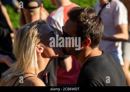 Junges Paar küssen in einer Menge Stockfoto