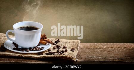 Kaffeetasse, Zimt und Anis auf altem Eistich und rustikalem Holztisch. Banner für heiße Getränke. Vintage Coffee Shop Menü Design Hintergrund. Stockfoto