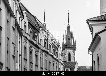 Zwei Türme der Kirche unserer Lieben Frau vor Tyn teilweise hinter alten Stadtgebäuden versteckt, Prag, Tschechische Republik. Schwarzweiß-Bild. Stockfoto