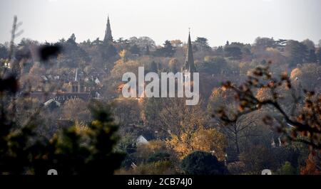 Kirchtürme ragen in diesem herbstlichen Foto, das in der Nähe von Maidenhead, England, aufgenommen wurde, vor einem grauen Himmel hervor Stockfoto