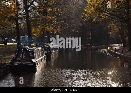 Rauch steigt von einem Boot, das im Kanalzentrum festgemacht ist An einem Herbsttag entlang des schönen Basingstoke Canal in Surrey Stockfoto