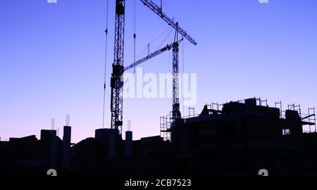 Baustelle mit Kränen bei Einbruch der Dunkelheit Stockfoto