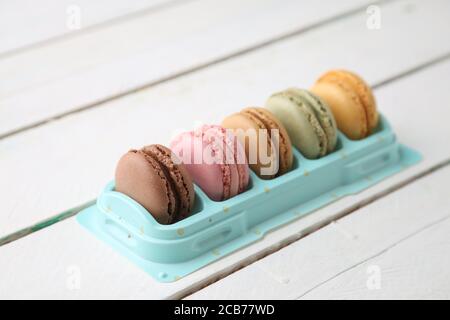 High-Angle-Aufnahme von einigen köstlichen und bunten Macarons isoliert Auf einer weißen Holzoberfläche Stockfoto