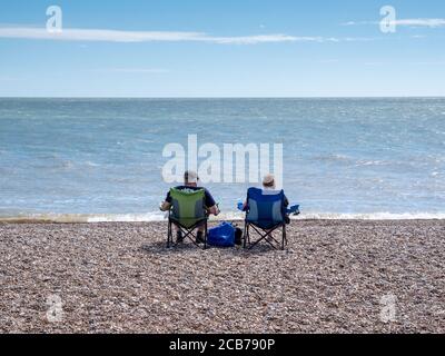 Zwei Personen sitzen auf dem Schindel Neach bei Aldeburgh Suffolk VEREINIGTES KÖNIGREICH Stockfoto