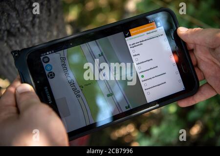 Verden, Deutschland. August 2020. Steffen Korig, Baumprüfer, betritt einen Baum in ein Online-System. Die Deutsche Bahn rüstet sich entlang ihres Streckennetzes mit regelmäßigen Vegetationsprüfungen gegen mögliche Gefahren durch fallende Bäume aus. Quelle: Sina Schuldt/dpa/Alamy Live News Stockfoto