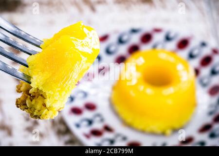 Stück Quindim, kleiner Pudding aus brasilianischem Ei geschnitten, mit Zucker und geriebener Kokosnuss. Makro- oder Nahaufnahme der brasilianischen Küche Stockfoto