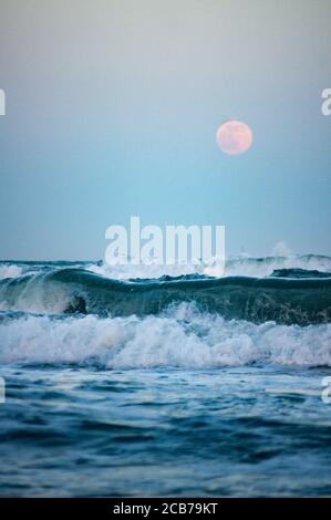 Wildes Meer mit Vollmond im Hintergrund, Fokus auf große Welle Stockfoto