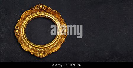 Vintage Luxus goldenen Rahmen mit kunstvollen barocken Dekoration auf rustikalen strukturierten schwarzen Hintergrund. Retro fancy Bilderrahmen für die Innenarchitektur. Stockfoto