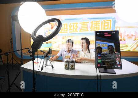 Quzhou, Chinas Provinz Zhejiang. Juli 2020. Der Dorfbewohner Chen Jiasheng (L) und der Livestreaming-Moderator Shao Jie präsentieren handgemachte Nudeln, die während eines Live-Videostreams in der Gemeinde Wantian in der Stadt Quzhou, ostchinesische Provinz Zhejiang, am 18. Juli 2020 verkauft werden. Mehr als 1,000 lokale Dorfbewohner haben Livestreaming im Village Livestreaming College gelernt, das seit seiner Gründung im April dieses Jahres vom chinesischen E-Commerce-Giganten Alibaba in Wantian Township eingerichtet wurde. Quelle: Huang Zongzhi/Xinhua/Alamy Live News Stockfoto