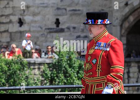 Eine Yeoman Warder, allgemein bekannt als Beefeater, am Tower of London, in zeremonieller Uniform während der Pistole Salute, London, England Stockfoto