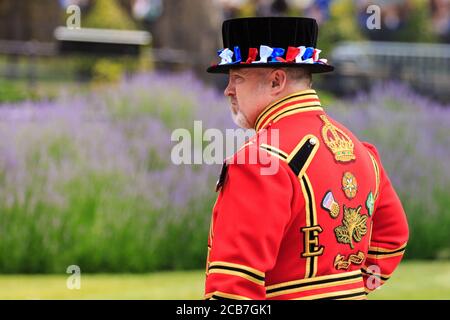 Eine Yeoman Warder, allgemein bekannt als Beefeater, am Tower of London, in zeremonieller Uniform während der Pistole Salute, London, England Stockfoto