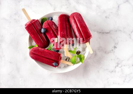 Nahaufnahme eines Tellers mit roten, hellen Heidelbeeren-Eiszapfen Stockfoto