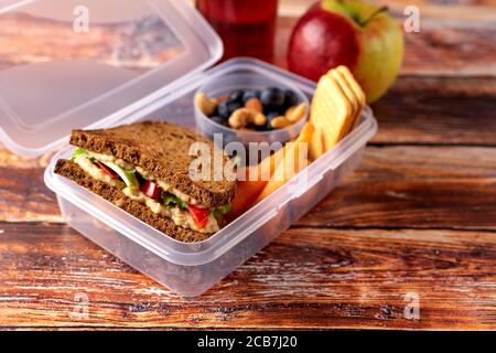 Nahaufnahme der Schullunch-Box mit veganem Sandwich, Nüssen und Beeren Stockfoto