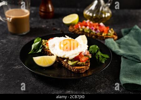 Nahaufnahme von Avocado-Toast mit Spiegelei und Tomaten Stockfoto