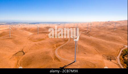 Luftaufnahme der Windturbinen und kurvige Straße weiter Wunderschöne goldene Berglandschaft in Kalifornien Stockfoto