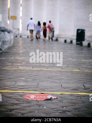 Rom, Italien. Juli 2020. Touristen spazieren durch die Kolonnaden auf dem Petersplatz in Rom. Auf dem Boden sind die Aufkleber und Klebestreifen abgeklort, was darauf hinweist, dass genügend Platz vorhanden ist. Die Reisebeschränkungen aufgrund der Corona-Pandemie werden wieder aufgehoben. Jetzt ist eine gute Zeit, um Rom zu entdecken. Quelle: Annette Riedl/dpa-Zentralbild/ZB/dpa/Alamy Live News Stockfoto