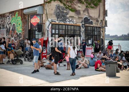 Am Eröffnungstag, Sonntag, 9. August 2020, erdulden die Käufer die Hitze auf dem Greenpoint Terminal Market. Der Markt behielt die extrabreiten Gänge aufrecht, eine Voraussetzung für Gesichtsbedeckung und soziale Distanzierungsprotokolle, da Käufer handwerkliche und antike Waren sowie eine Auswahl von Lebensmittelhändlern durchstöberten. (© Richard B. Levine) Stockfoto