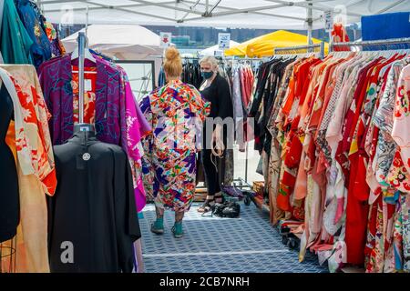 Am Eröffnungstag, Sonntag, 9. August 2020, erdulden die Käufer die Hitze auf dem Greenpoint Terminal Market. Der Markt behielt die extrabreiten Gänge aufrecht, eine Voraussetzung für Gesichtsbedeckung und soziale Distanzierungsprotokolle, da Käufer handwerkliche und antike Waren sowie eine Auswahl von Lebensmittelhändlern durchstöberten. (© Richard B. Levine) Stockfoto