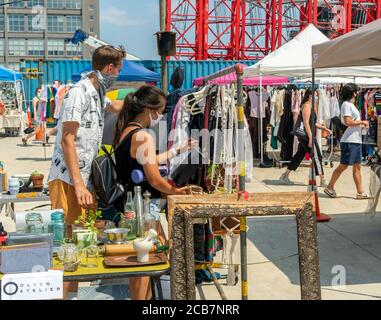 Am Eröffnungstag, Sonntag, 9. August 2020, erdulden die Käufer die Hitze auf dem Greenpoint Terminal Market. Der Markt behielt die extrabreiten Gänge aufrecht, eine Voraussetzung für Gesichtsbedeckung und soziale Distanzierungsprotokolle, da Käufer handwerkliche und antike Waren sowie eine Auswahl von Lebensmittelhändlern durchstöberten. (© Richard B. Levine) Stockfoto