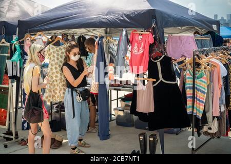 Am Eröffnungstag, Sonntag, 9. August 2020, erdulden die Käufer die Hitze auf dem Greenpoint Terminal Market. Der Markt behielt die extrabreiten Gänge aufrecht, eine Voraussetzung für Gesichtsbedeckung und soziale Distanzierungsprotokolle, da Käufer handwerkliche und antike Waren sowie eine Auswahl von Lebensmittelhändlern durchstöberten. (© Richard B. Levine) Stockfoto