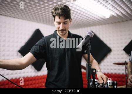 Porträt eines lächelnden Mannes Einstellung Mikrofon auf dem Ständer Stockfoto
