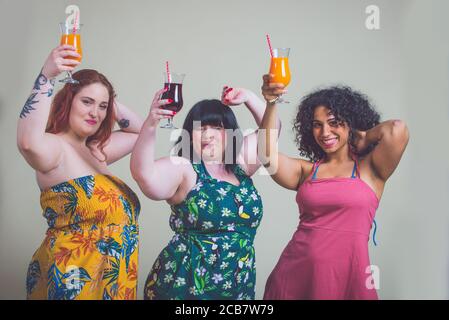 Plus Größe Frauen machen Party. Kurvige multiethnische Mädchen tragen Kleider und Spaß haben Stockfoto