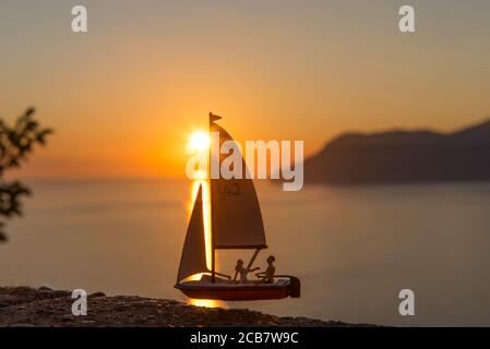 Miniatur Menschen Segeln, Sonnenuntergang Hintergrund Stockfoto