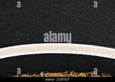 Breite geschwungene reflektierende Band an einem Kreisverkehr, ein abstraktes Straßendetail. Stockfoto