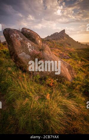 Morgensonne auf einem Felsbrocken, der auf einem Hügel bei Ramshaw Rocks im britischen Peak District National Park ruht. Stockfoto