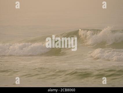 Ocean Waves asthe Sun Rises on a Foggy Gay at Ein Florida Strand Stockfoto