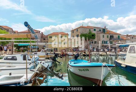 Postira, Kroatien August 2020 Blick auf eine kleine Stadt auf der Insel brac, kroatien. Alte Boote dockten an und Leute gingen während des Covid g vorbei Stockfoto