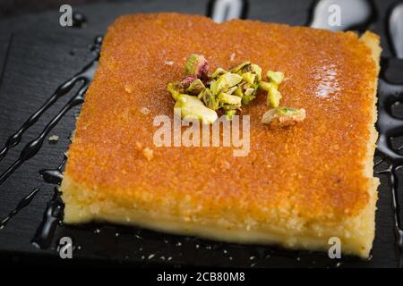 Ein Stück Kunafa arabisches Süßgebäck Dessert auf Gericht mit cremigem Käse Pistazie. Stockfoto