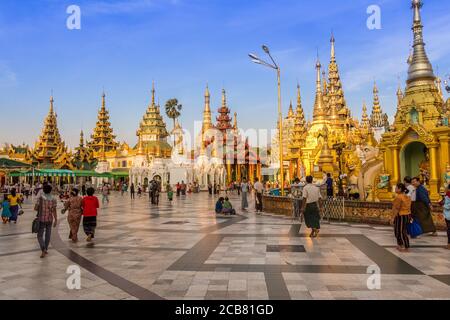 Yangon, Myanmar - 18. Dezember 2017: Menschen, die in der Abendsonne um die Shwedagon-Pagode gehen, Yangon, Myanmar Stockfoto