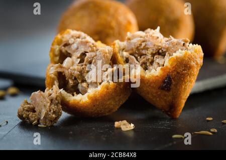 Traditionelles arabisches türkisches sirianisches Kibbeh mit Lamm und Pinienkernen. Draufsicht. Natürlicher Holzhintergrund Stockfoto