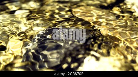 Goldene Reflexe auf der Wasseroberfläche, glattes Gold und dunkler Hintergrund mit kreisförmigen Mustern. Perfektes Hintergrundbild. Steine im Hintergrund Stockfoto