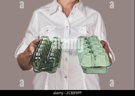 Auswahl an ökologischen Verpackungen. Das Mädchen hält in den Händen zwei Päckchen für Eier. Stockfoto